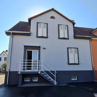 Maison rénovée avec façade bicolore et escalier extérieur – Güven Rénovation Mulhouse